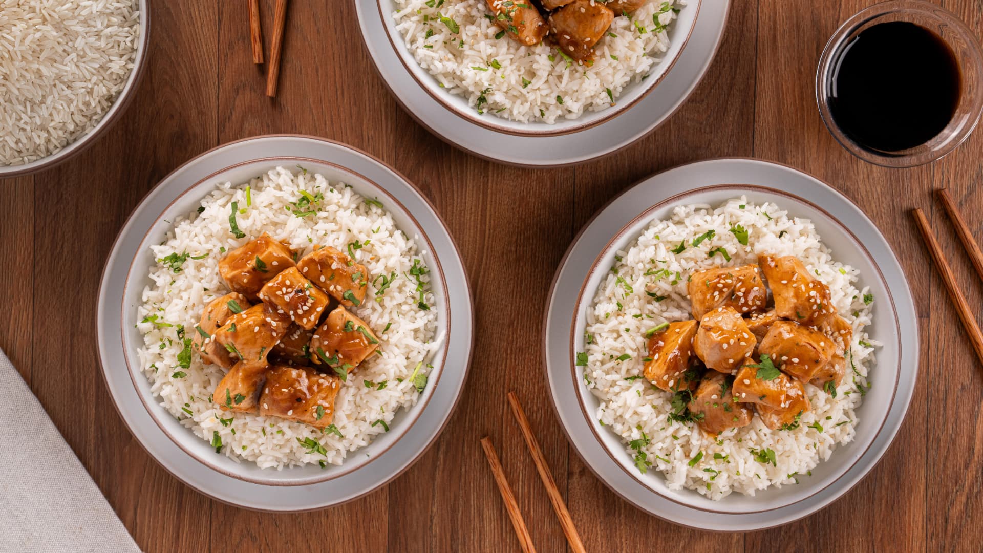 Arroz con cerdo agridulce servido en platos sobre mesa de madera