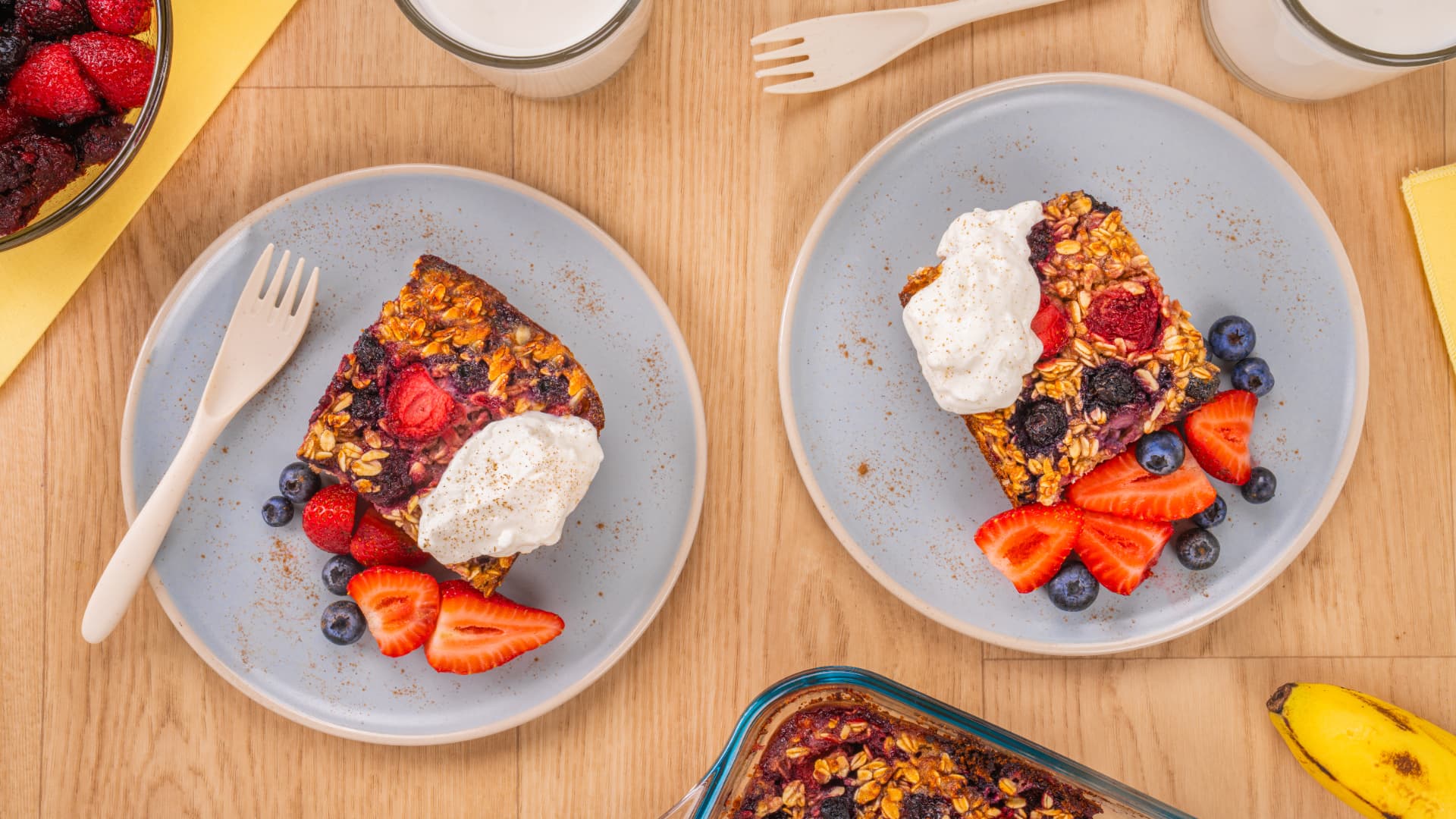 Avena horneada con moras, crema, fresas y arándanos sobre mesa de madera, fotografía horizontal